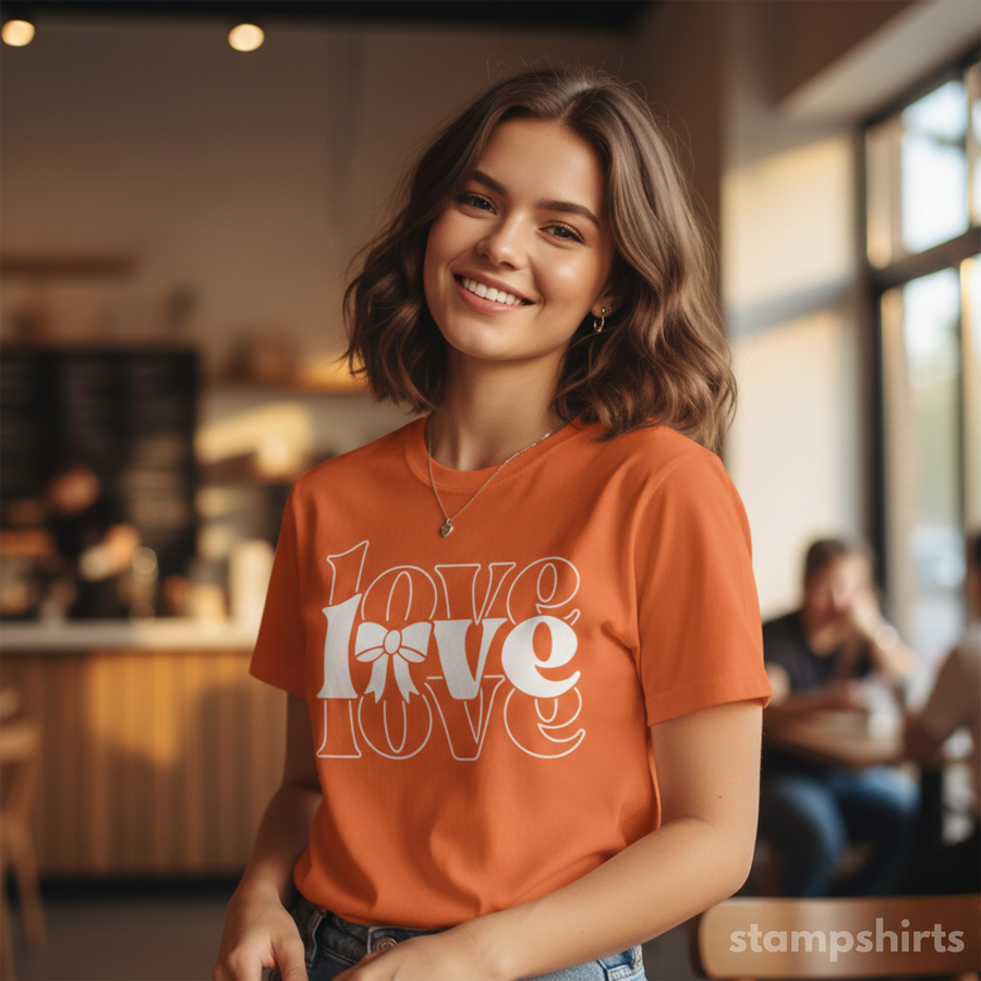 Woman wearing an orange t-shirt with 'LOVE' printed on it in a casual setting.