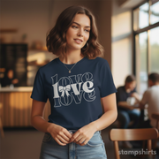 Woman wearing a navy blue t-shirt with 'LOVE' printed on it in a casual setting.