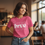 Woman wearing a pink t-shirt with 'LOVE' design in a casual setting
