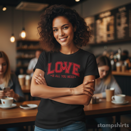 Woman wearing a black t-shirt with 'LOVE is all you need' text in a cafe setting thumbnail 7