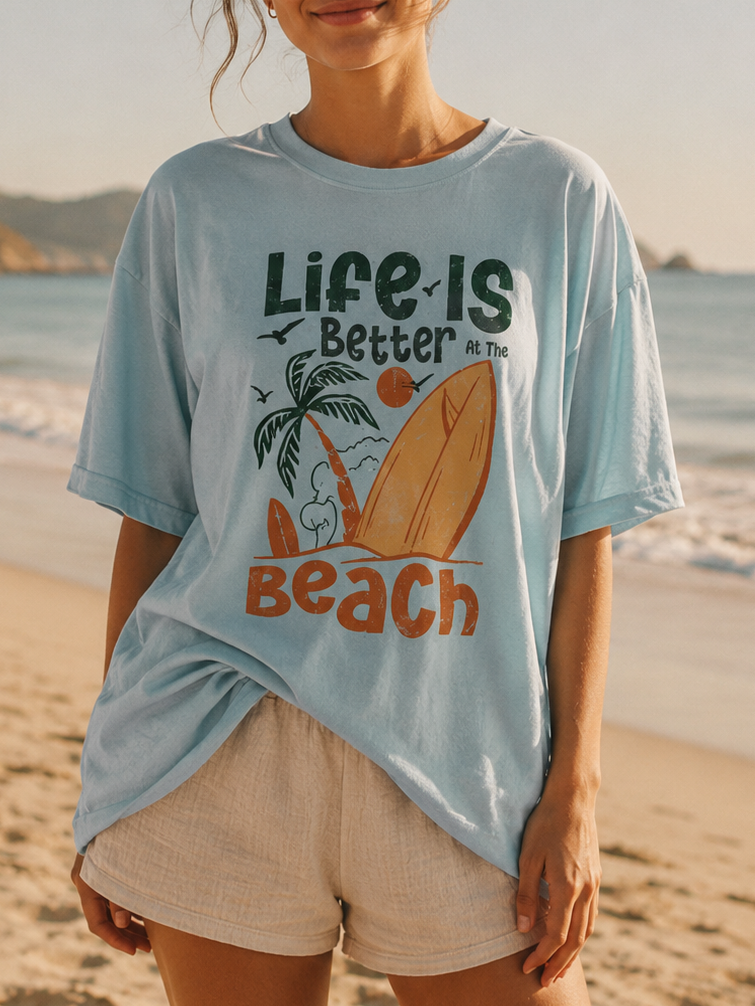 Woman wearing a 'Life is Better at the Beach' t-shirt on a beach.
