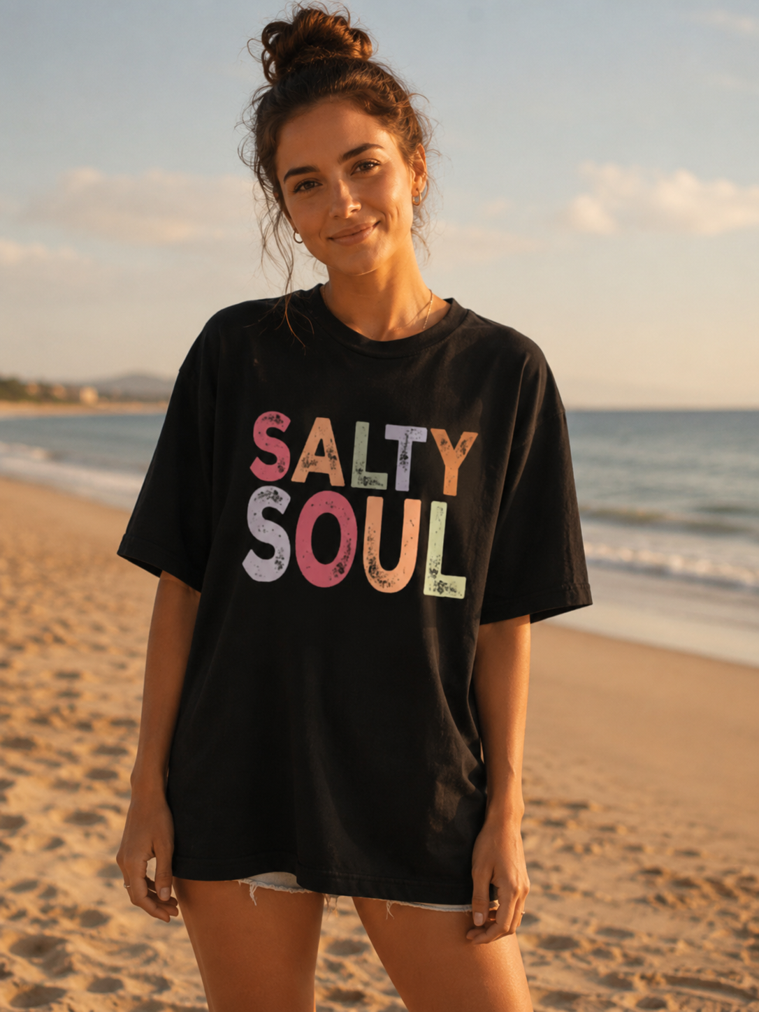 Woman wearing a black t-shirt with 'Salty Soul' on it at the beach.