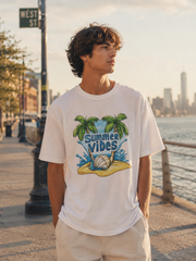 Person wearing a 'Summer Vibes' t-shirt by a waterfront with a city skyline in the background.