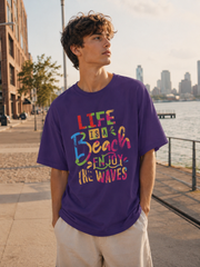 Person wearing a purple t-shirt with colorful text by a waterfront with city skyline.