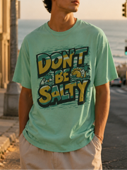 Man wearing a 'Don't Be Salty' t-shirt by the seaside