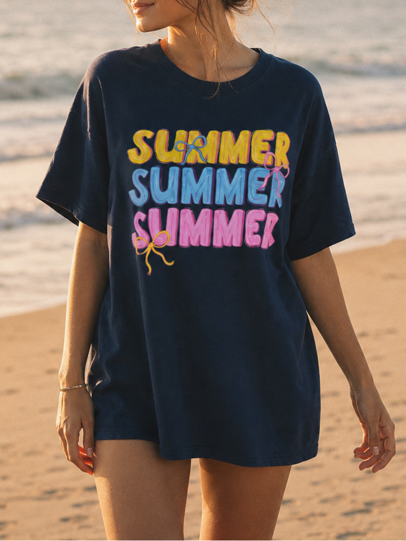 Woman wearing a navy blue t-shirt with 'SUMMER SUMMER SUMMER' text on a beach.