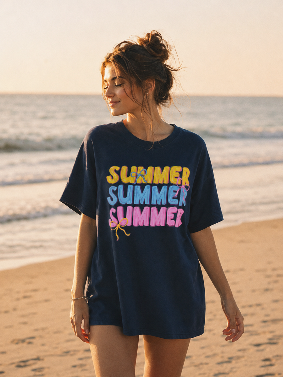 Woman wearing a navy blue t-shirt with 'SUMMER SUMMER SUMMER' text on a beach.