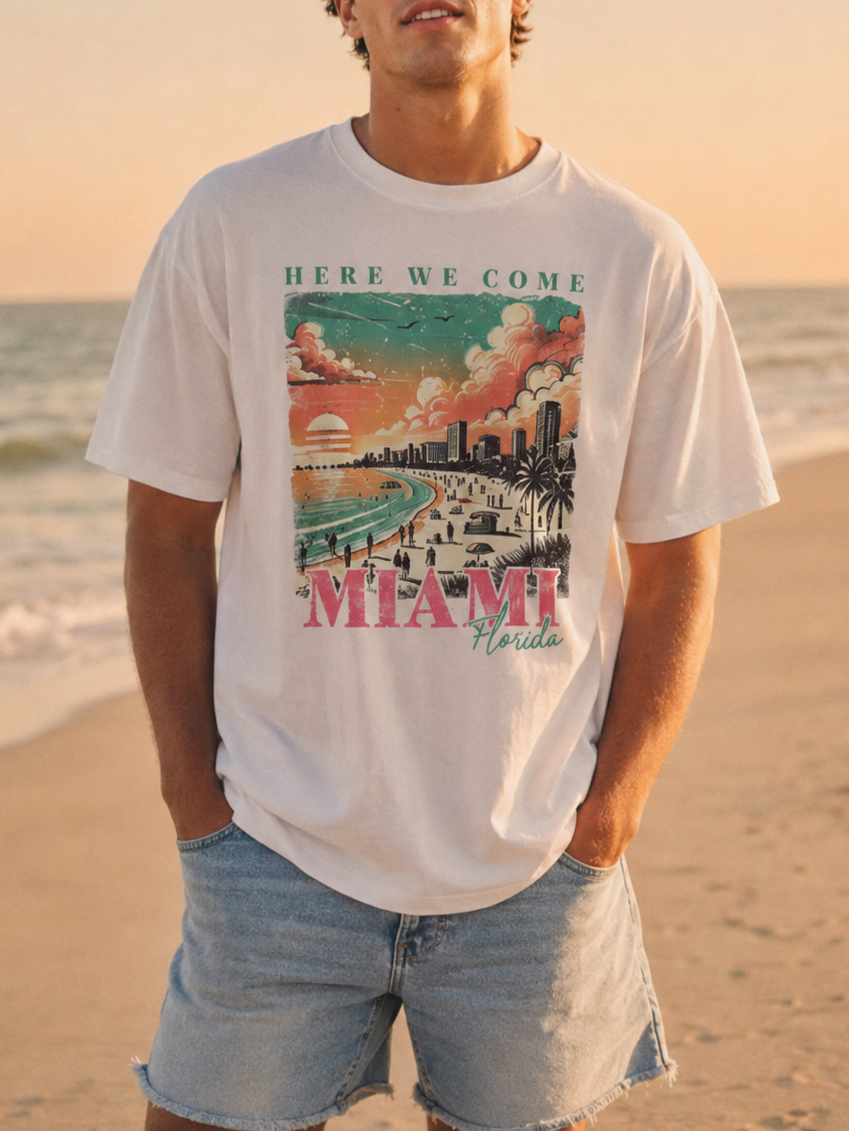 Person wearing a t-shirt with a Miami graphic on a beach at sunset
