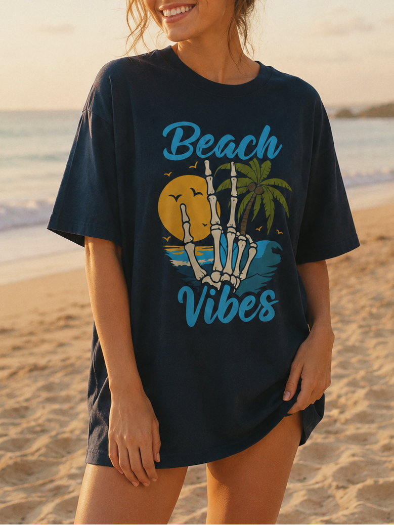 Woman wearing a 'Beach Vibes' t-shirt on a beach at sunset