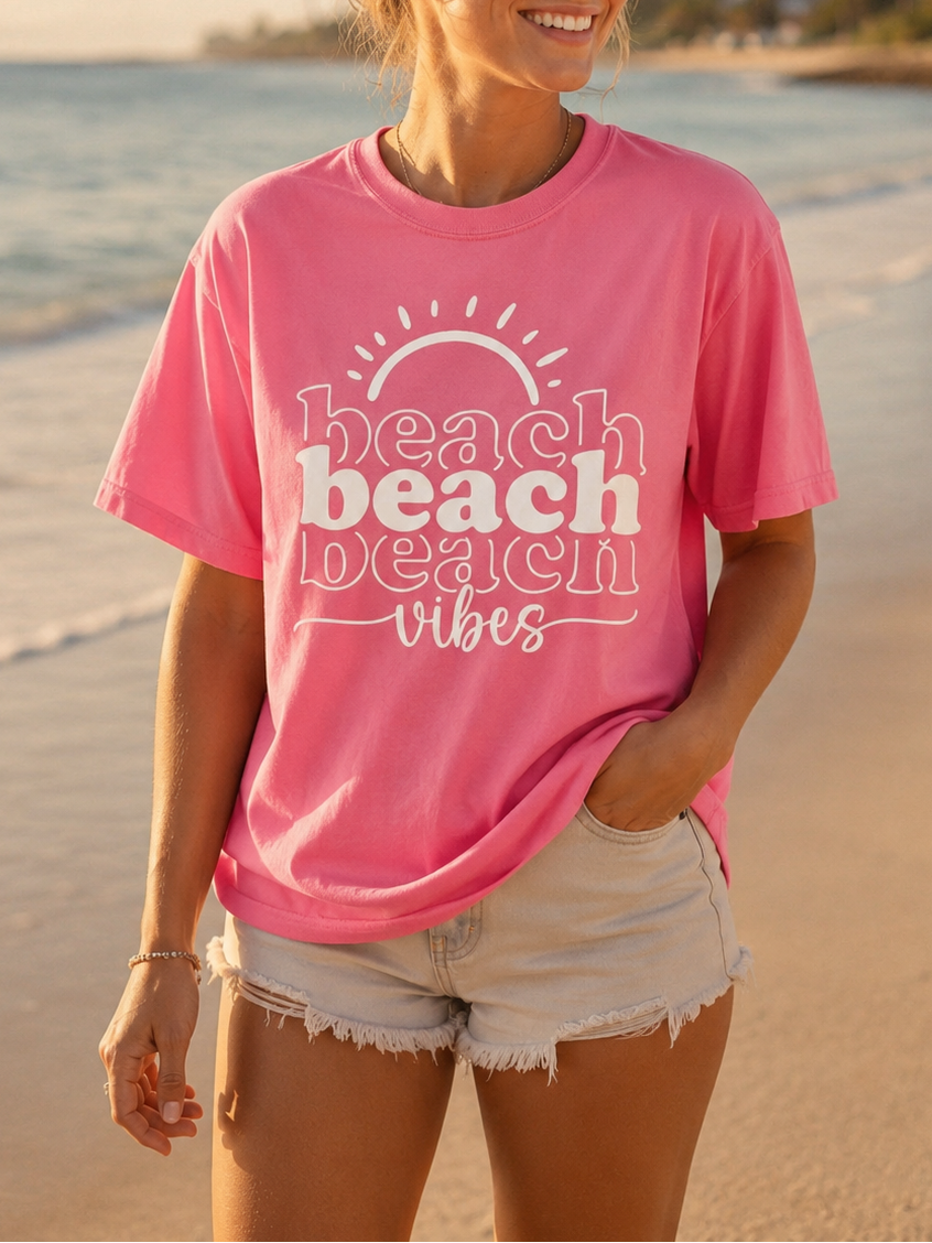Woman wearing a pink 'beach vibes' t-shirt on a beach