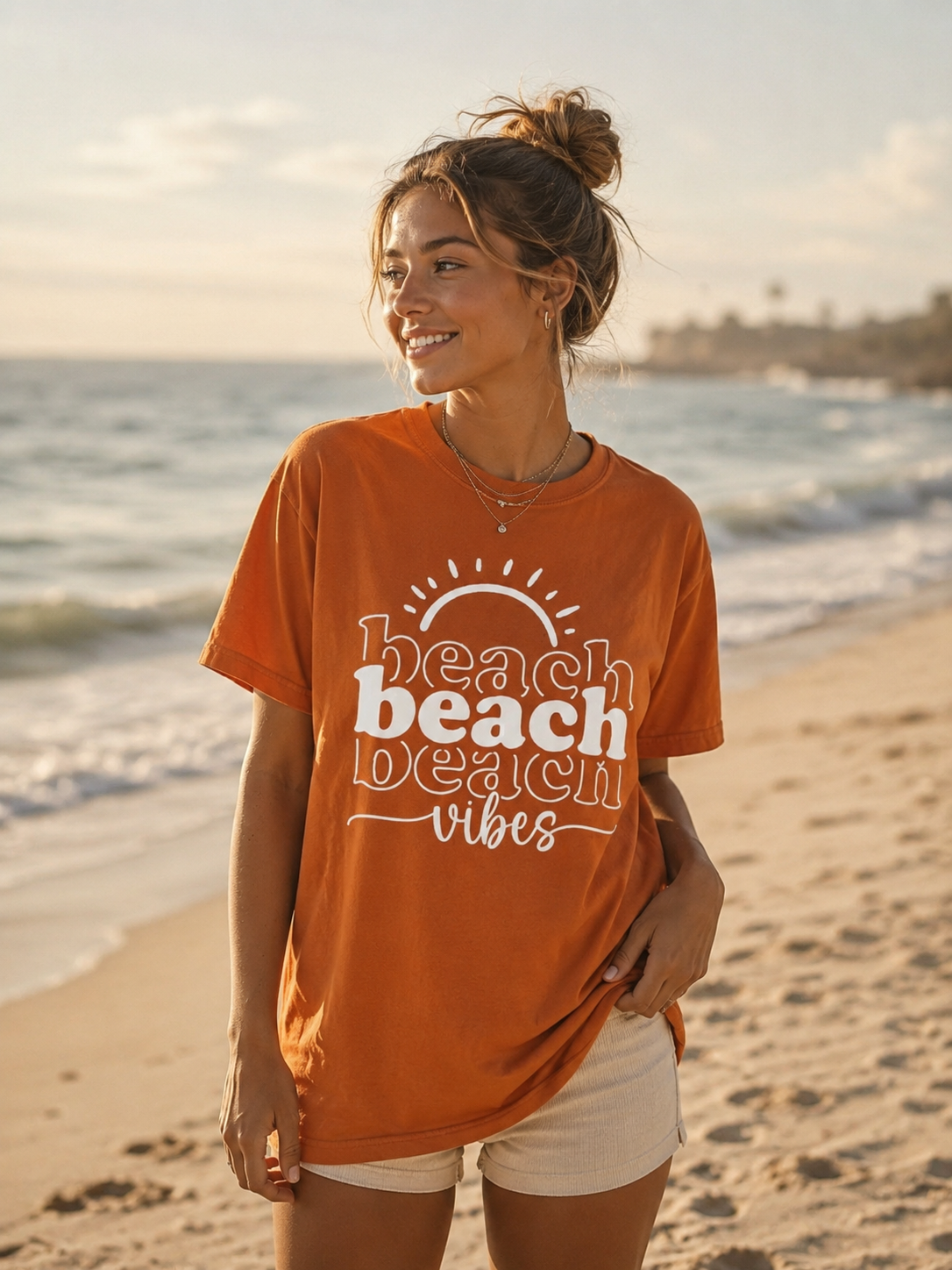 Woman wearing an orange 'beach vibes' t-shirt on a beach