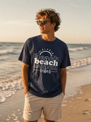Man wearing a navy blue t-shirt with 'beach vibes' text on a beach