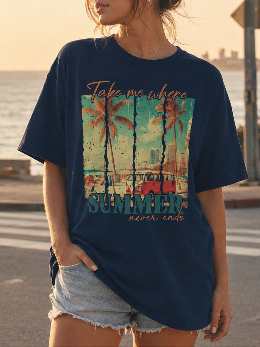 Woman wearing a navy blue t-shirt with a beach graphic and text by the ocean.
