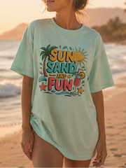 Woman wearing a 'Sun, Sand, and Fun' t-shirt on a beach at sunset.