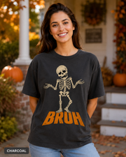 Female model wearing Charcoal BRUH shrugging skeleton Halloween T-shirt