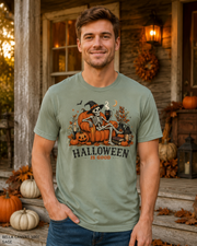 Male model wearing the Bella Canvas 3001 Sage Halloween Is Good skeleton pumpkin chair T-shirt