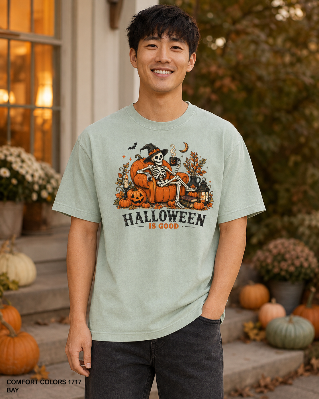 Male model wearing the Comfort Colors 1717 Bay Halloween Is Good skeleton pumpkin chair T-shirt