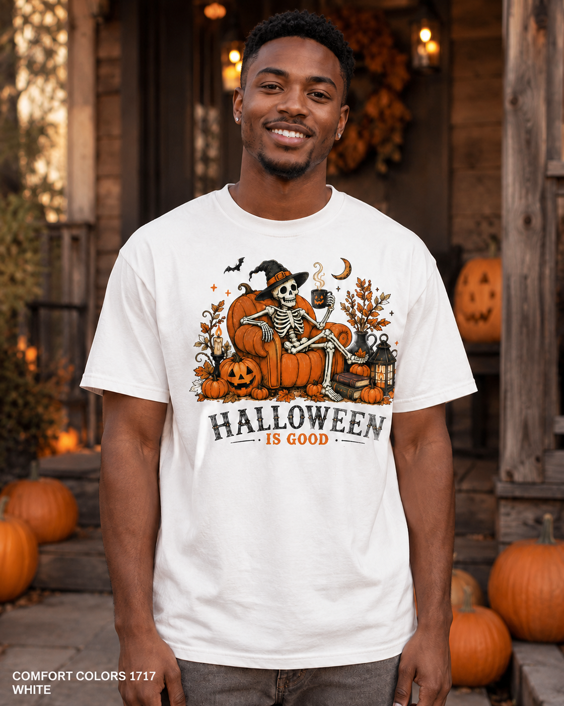 Male model wearing the Comfort Colors 1717 White Halloween Is Good skeleton pumpkin chair T-shirt