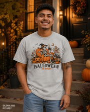 Male model wearing the Gildan 2000 Ice Grey Halloween Is Good skeleton pumpkin chair T-shirt
