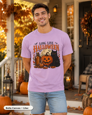 Male model wearing Long Live Halloween black cat and pumpkin T-shirt in Bella Canvas Lilac