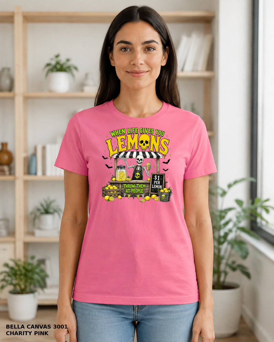 Female model wearing Bella Canvas 3001 Charity Pink When Life Gives You Lemons skeleton Halloween T-shirt, artwork positioned slightly lower