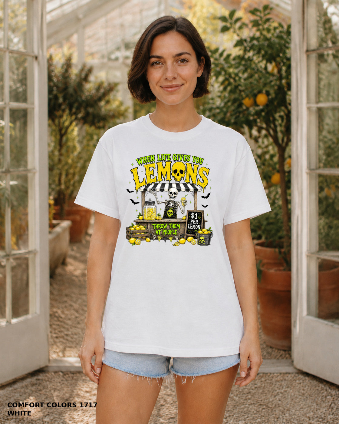 Female model wearing Comfort Colors 1717 White When Life Gives You Lemons skeleton Halloween T-shirt, artwork positioned slightly lower