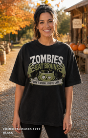 Female model wearing the Comfort Colors 1717 Black Zombies Eat Brains funny Halloween T-shirt