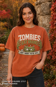 Female model wearing the Comfort Colors 1717 Burnt Orange Zombies Eat Brains funny Halloween T-shirt